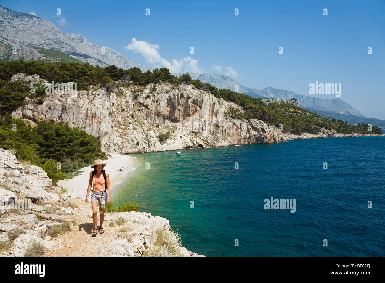 Una donna che cammina su un sentiero lungo la costa del sole, spiaggia Nudal, Dalmazia, Croazia, Europa Foto Stock