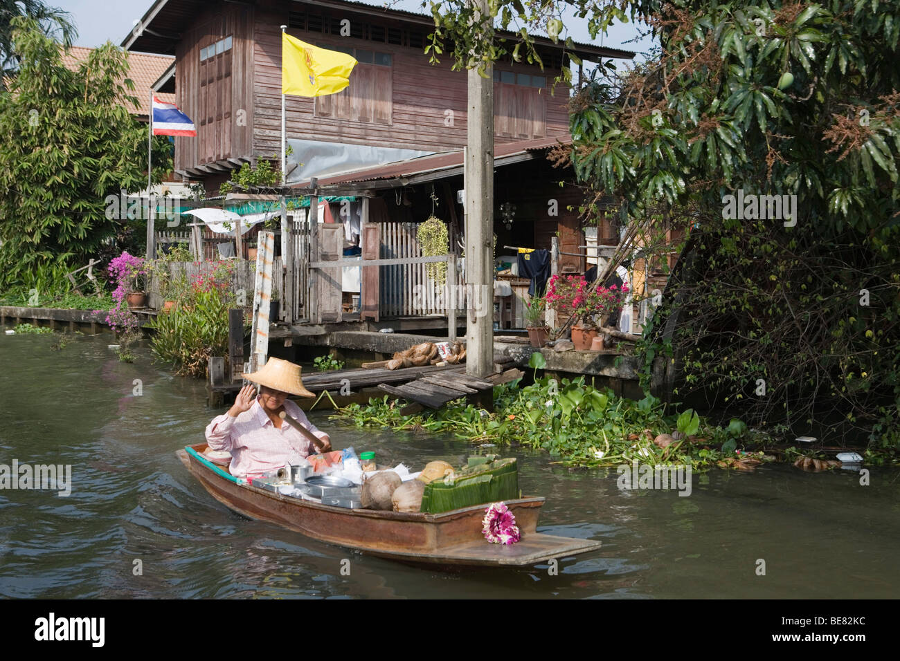 La donna in un longtail boat sul modo per il mercato galleggiante di Bangkok, Tailandia Foto Stock