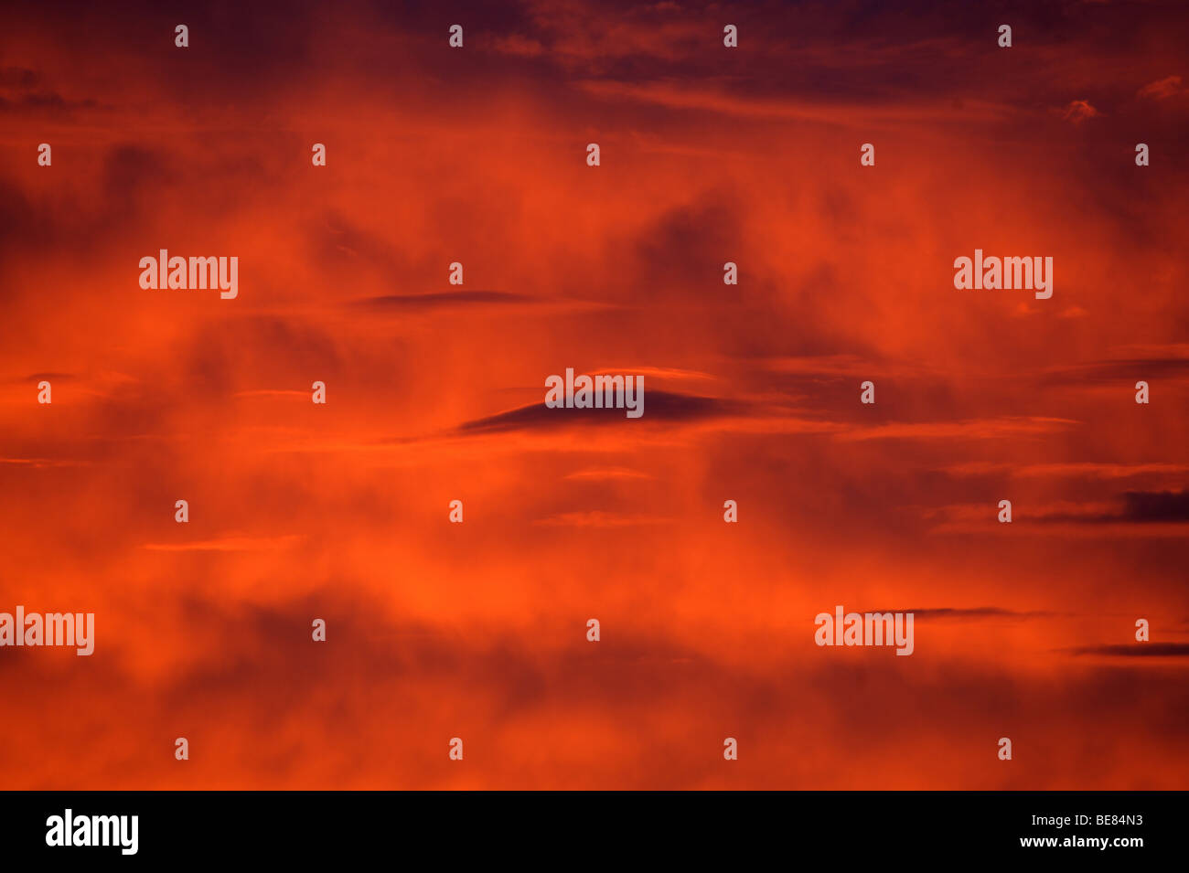 Nuvole lenticolari mostrato contro un profondo rosso e arancione tramonto infuocato guardare quasi come alien i visitatori nel cielo Foto Stock