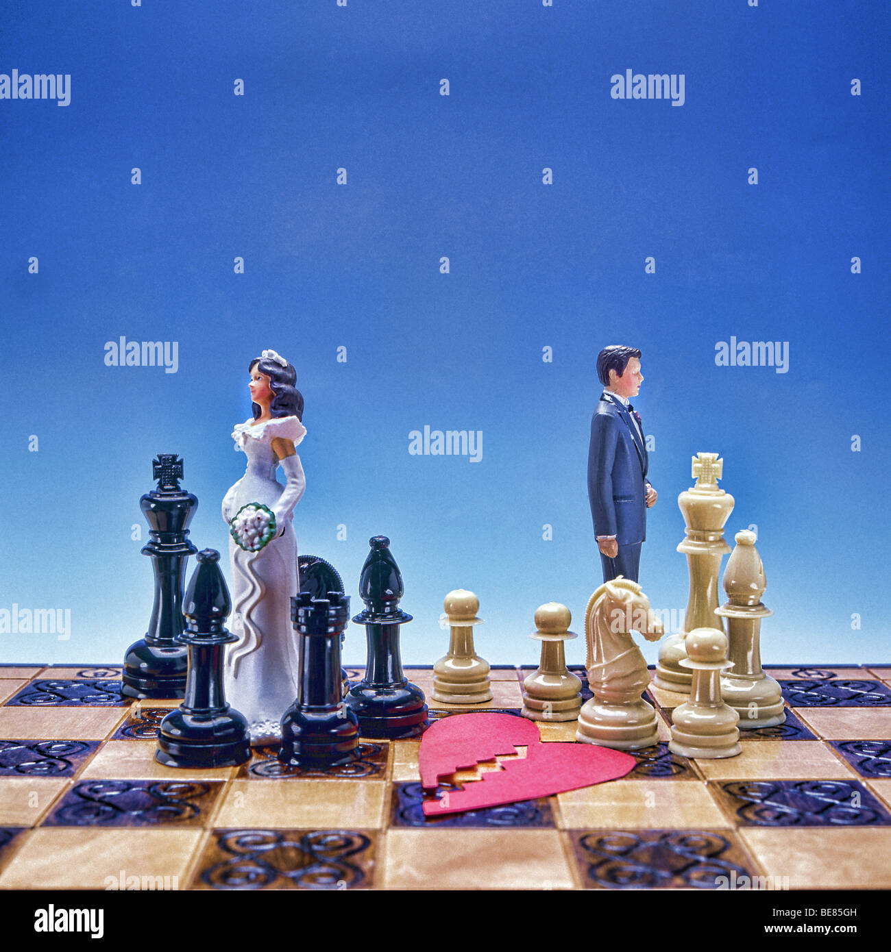 Simbolica rappresentazione del divorzio con la sposa e lo sposo dalla torta nuziale e il cuore spezzato a pezzi separati in divisa Foto Stock