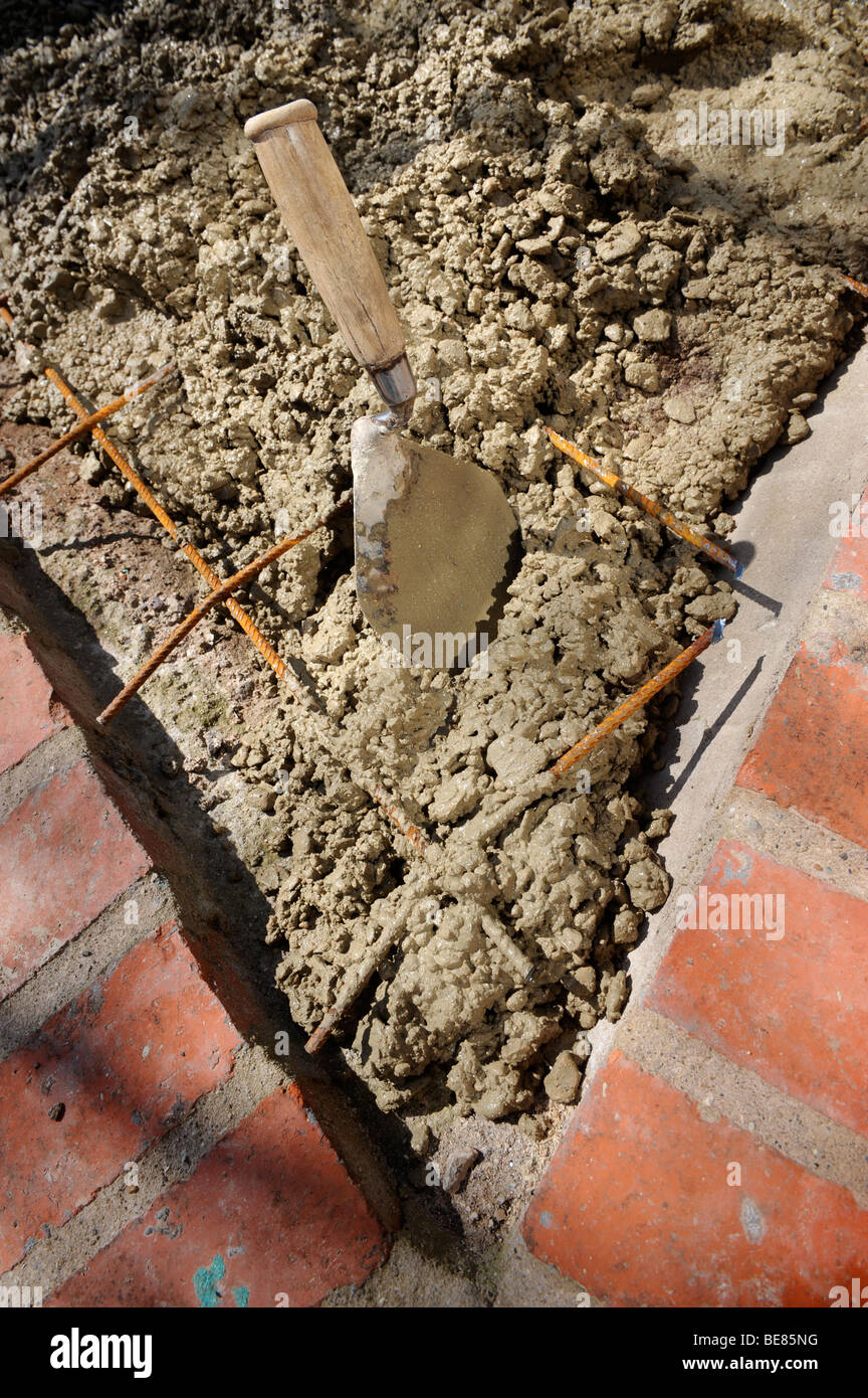 Dettaglio di diffusione di calcestruzzo con un costruttori TROWELL sulla maglia di acciaio nella costruzione di un disco permanente AREA PARCHEGGIO REGNO UNITO Foto Stock