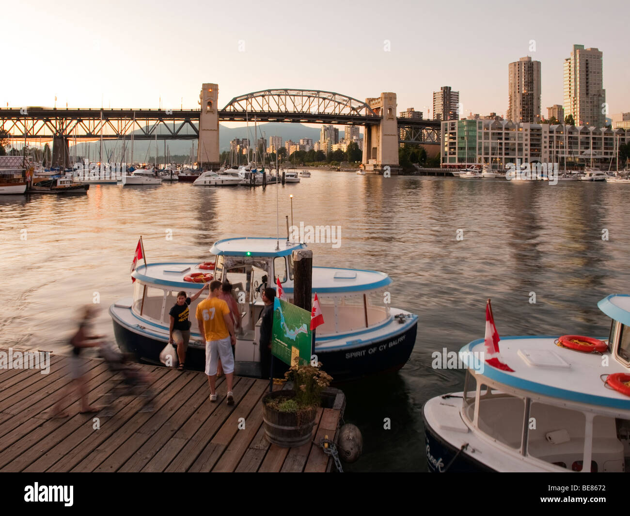 Vista di False Creek e Burrard Bridge da Granville Island, Vancouver, Canada. Un piccolo traghetto pedonale è al dock. Foto Stock