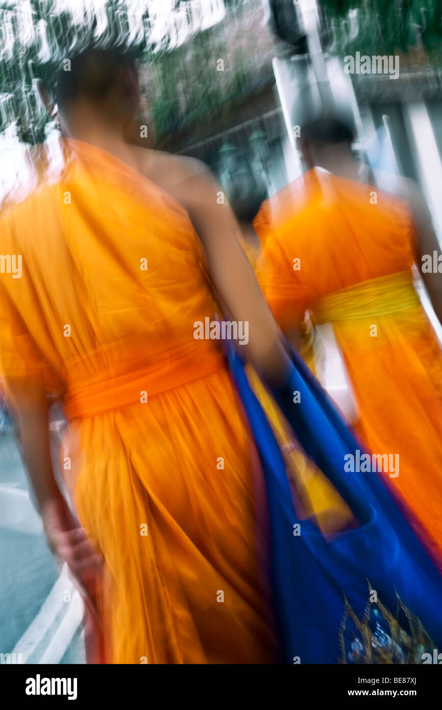 Thailandia, Bangkok, Wat Suthat tempio, due arancio-derubato, giovane debuttante monaci a piedi attraverso il tempio motivi Foto Stock
