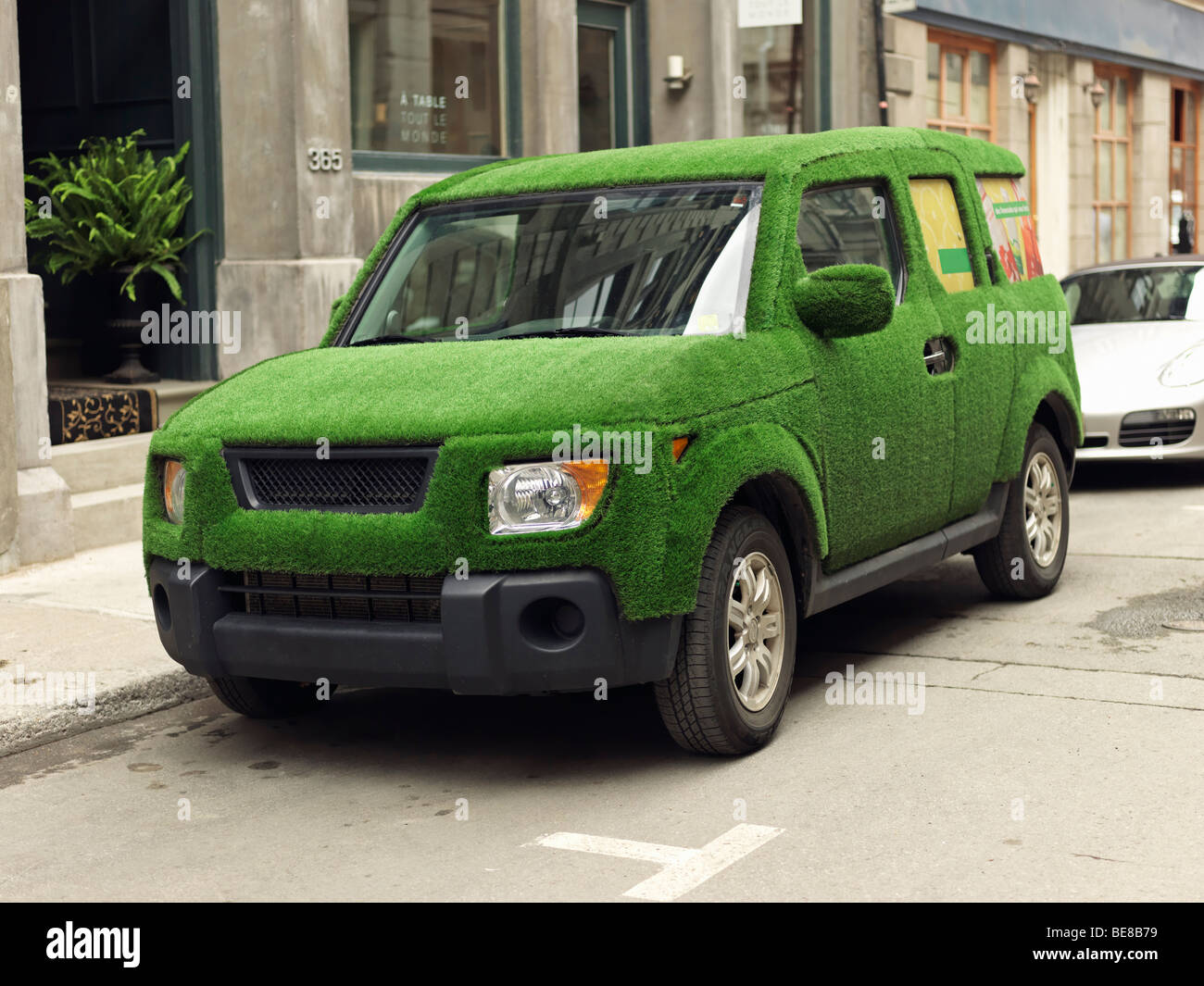 SUV ricoperto di erba verde raffigurante un enviro-friendly automobile Foto Stock