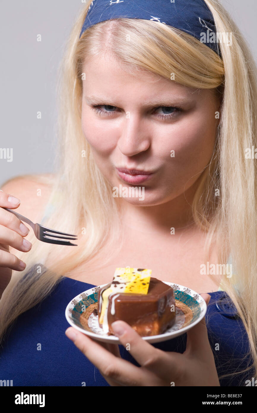 Fat giovane donna è mangiare la torta. Foto Stock