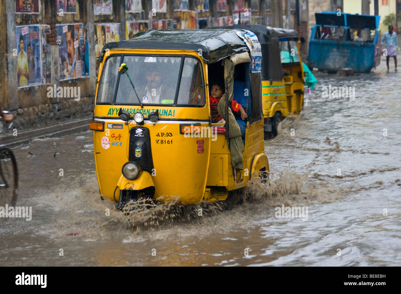 In rickshaw cavalcando attraverso strade allagate in Hyderabad India Foto Stock