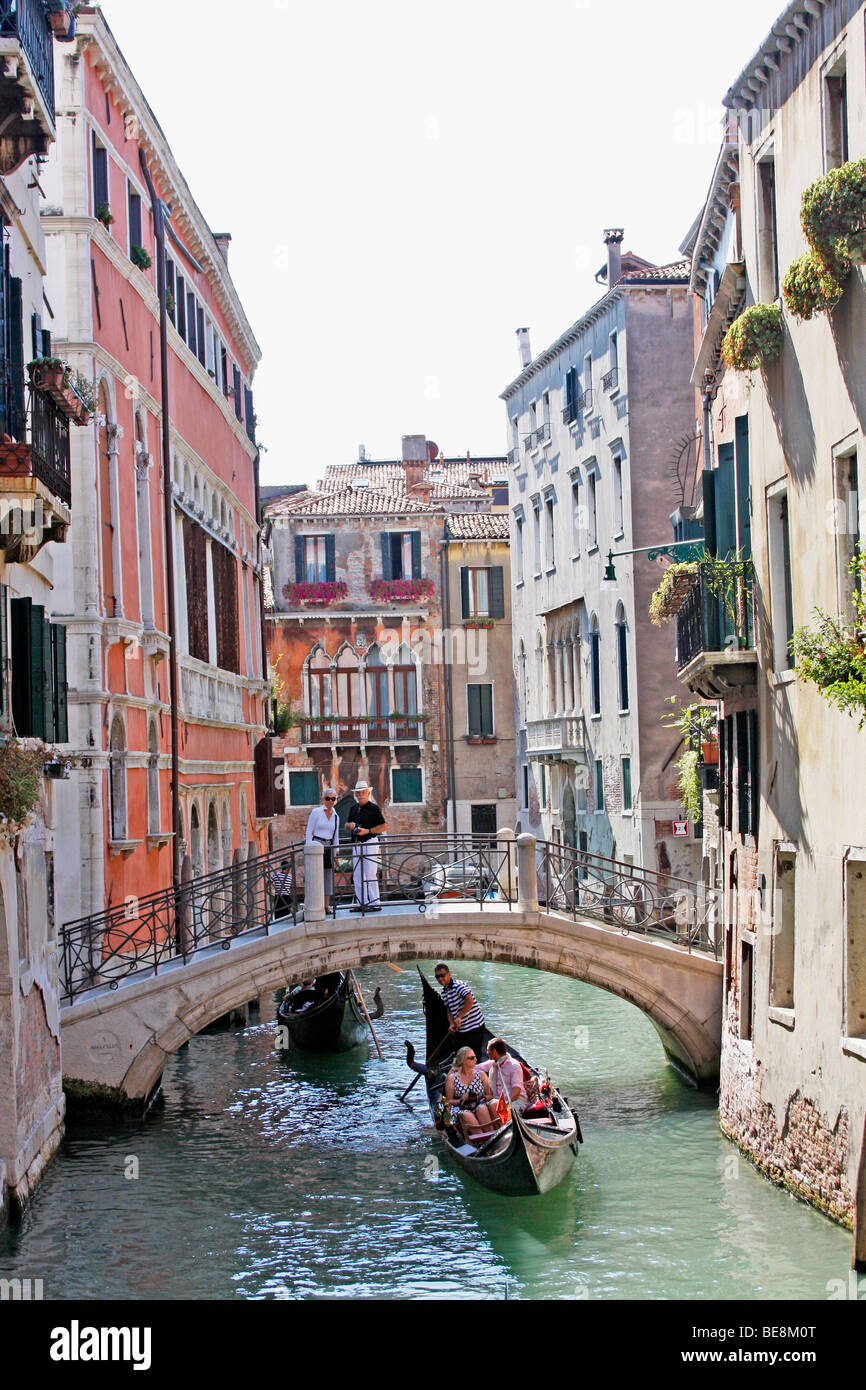 Gondolieri portano i turisti a Venezia su un giro in barca attraverso i canali di meraviglioso della città.Italia Foto Stock