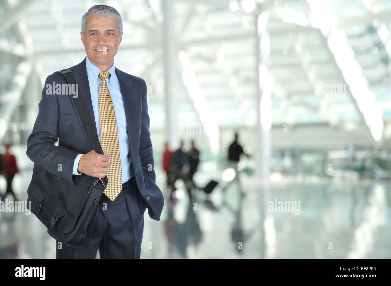 Viaggiatori di affari in aeroporto Concourse con viaggiatori sfocata in background Foto Stock