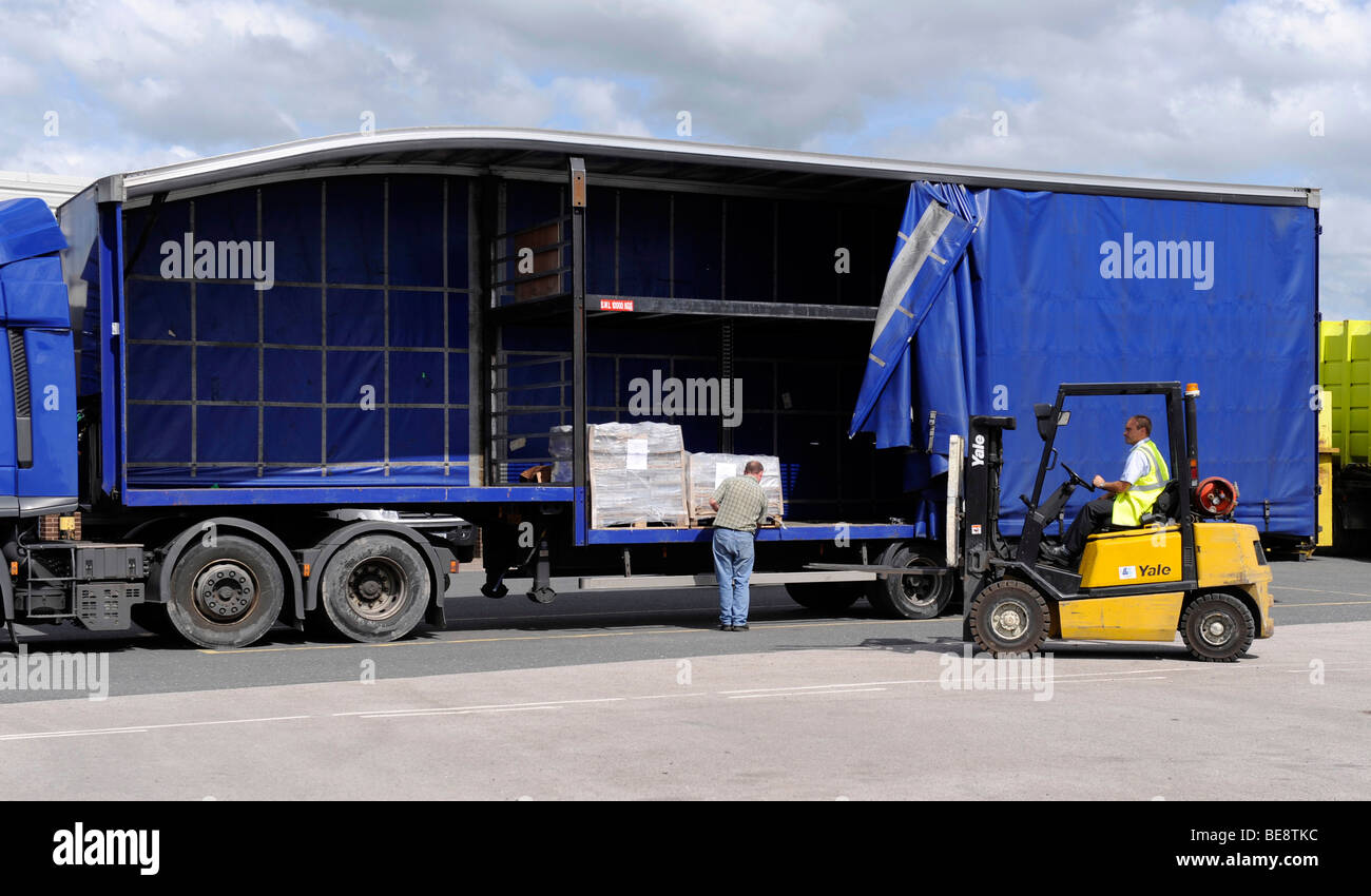 Un carrello elevatore a forche carica scarica un double deck curtainsided rimorchio e carrello Foto Stock