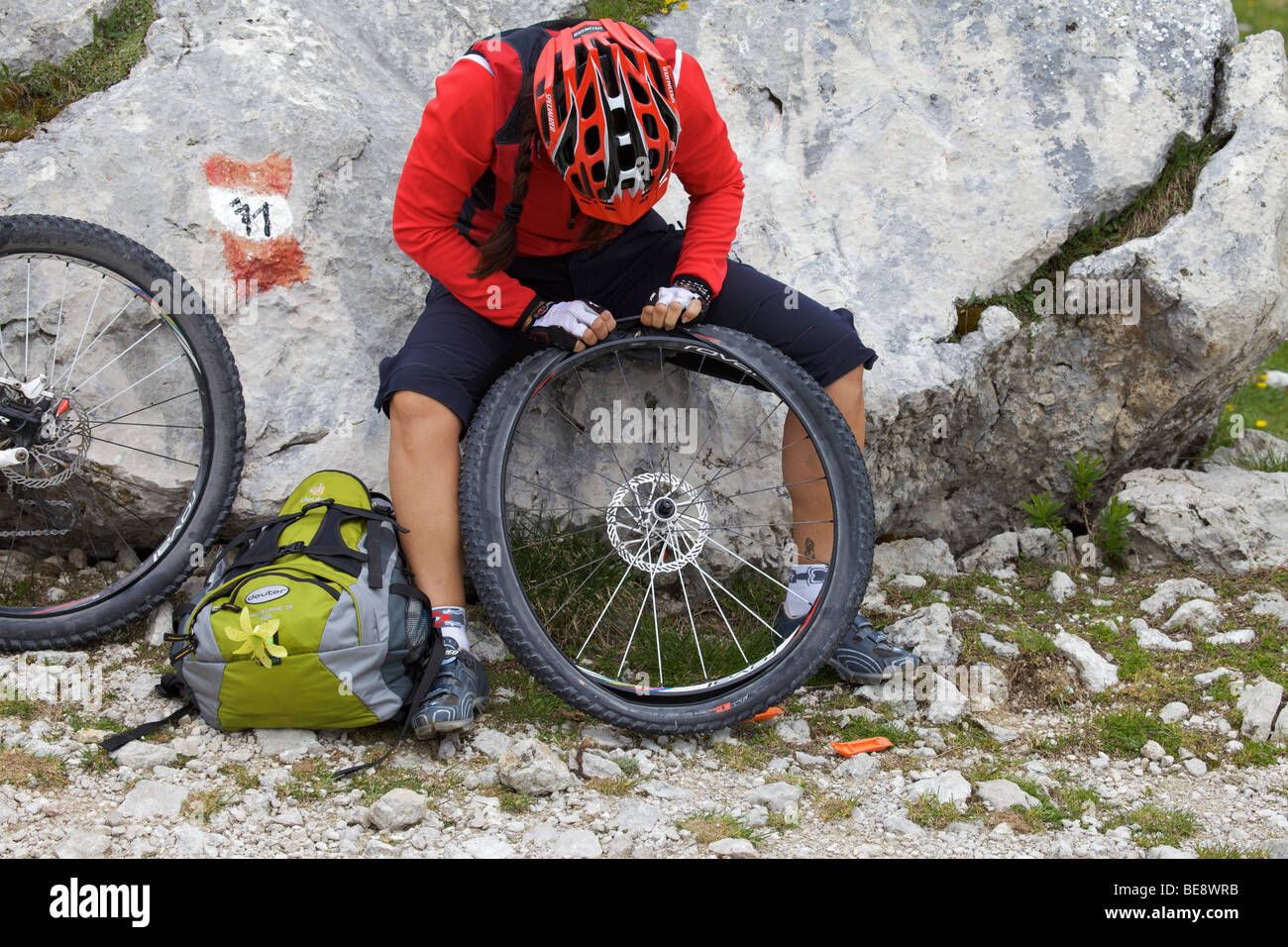 Mountain bike rider la riparazione di un piatto di pneumatico anteriore Foto Stock