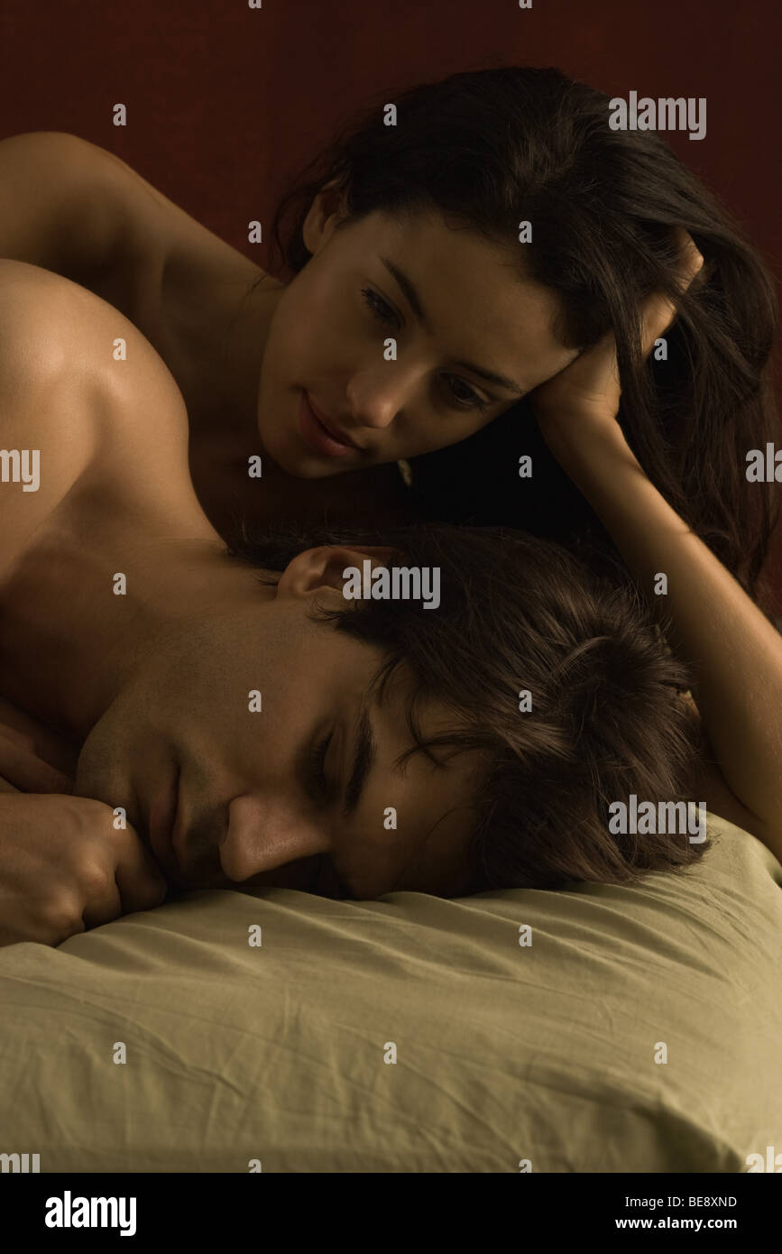 Coppia insieme a letto, donna uomo guarda il sonno Foto Stock