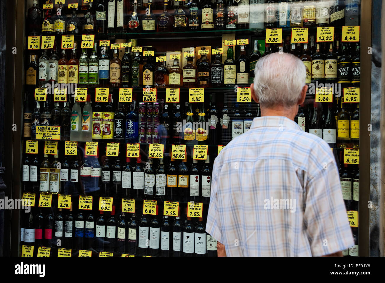 Persona che guarda i prezzi di alcool in un angolo tradizionale negozio nel Barri Gotic. Barcellona. Spagna Foto Stock