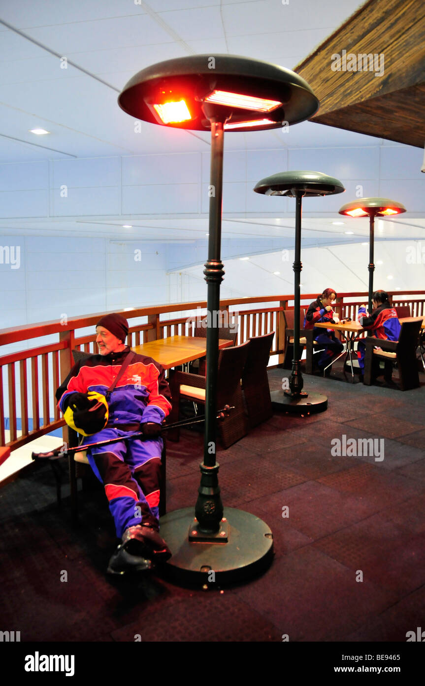 Gli sciatori in fase di riscaldamento sotto i riscaldatori esterni, Ski Dubai indoor sci hall nel centro commerciale Mall of the Emirates, Dubai, Emirati Arabi Uniti, Foto Stock