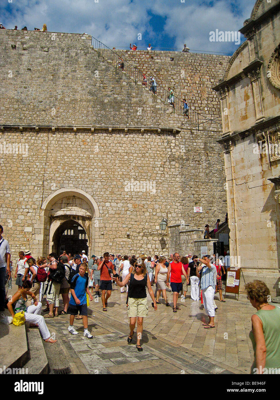 Croazia; Hrvartska; Kroatien; Dubrovnik, turistico entrare attraverso la pila di gate e di salire le scale per prendere le mura di fortificazione a piedi Foto Stock