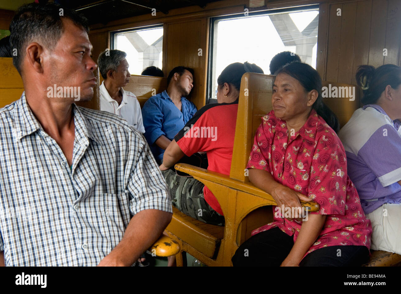 Stanchi passeggeri del treno di terza classe che si avvicinano alla fine del viaggio verso la stazione Hua Lampong di Bangkok, Thailandia Foto Stock