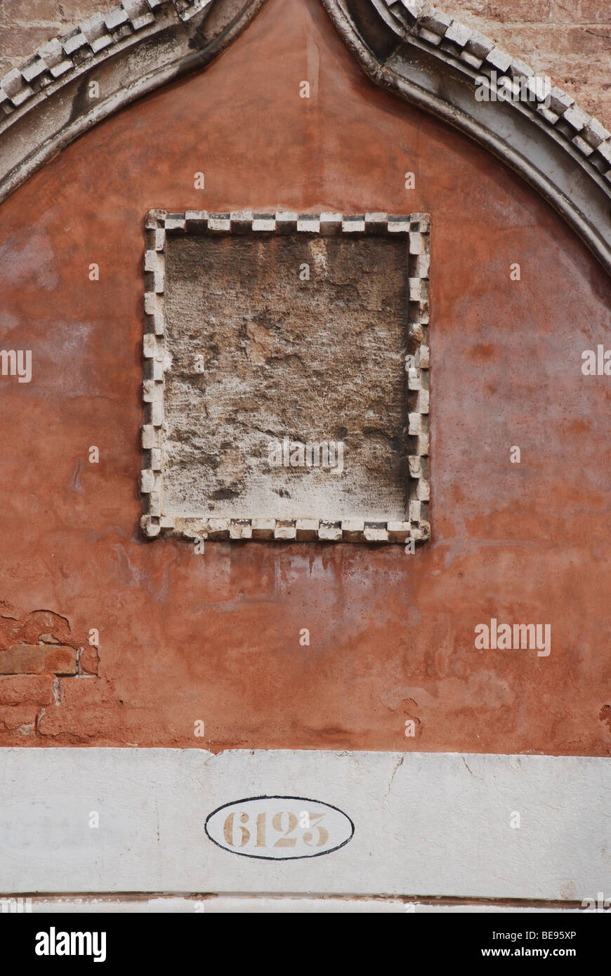 Parete testurizzata e vuoto al di sopra della placca porta a Venezia, Italia. Foto Stock