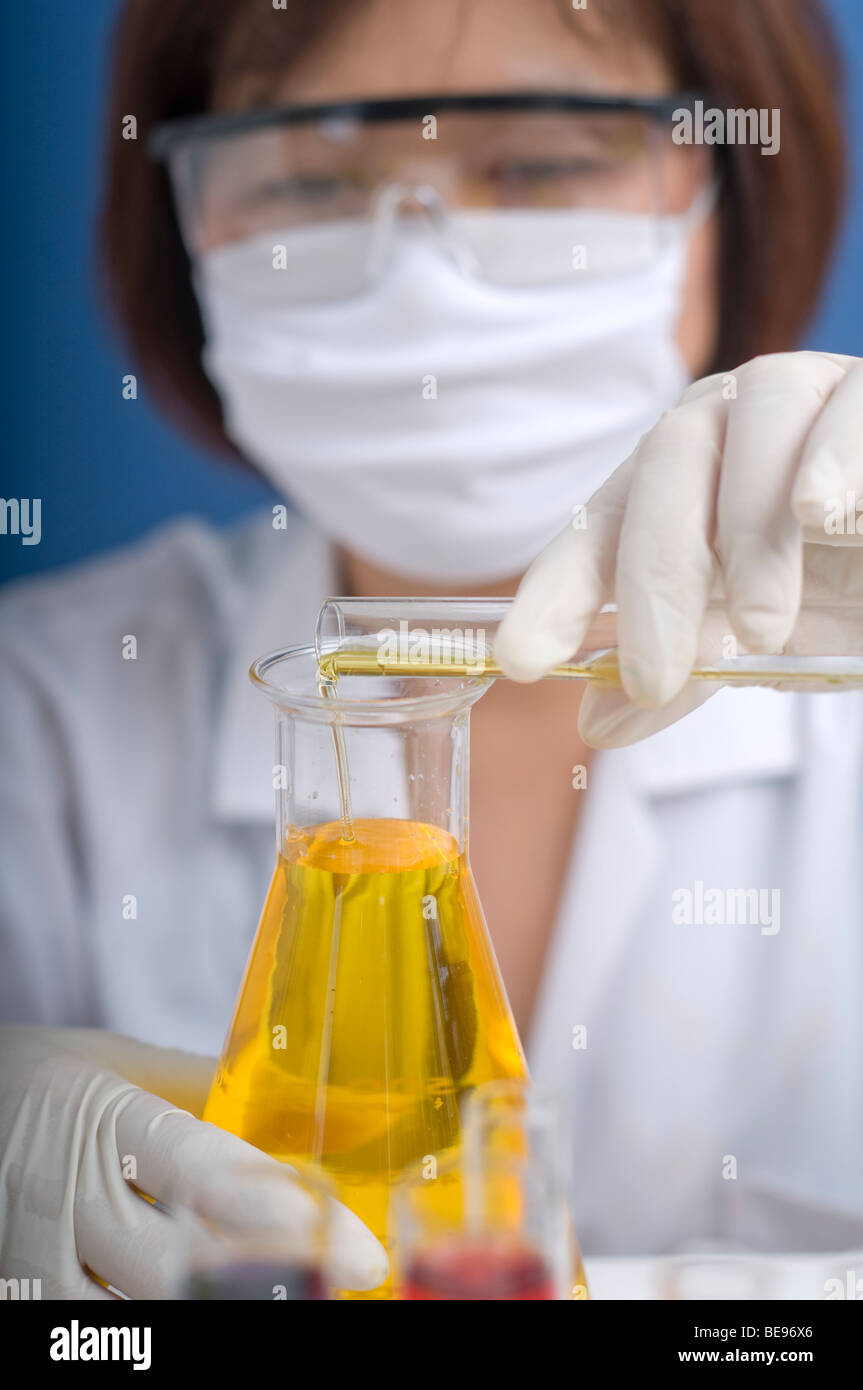 Donna asiatica che lavora in un laboratorio medico con la provetta e il pallone. Foto Stock