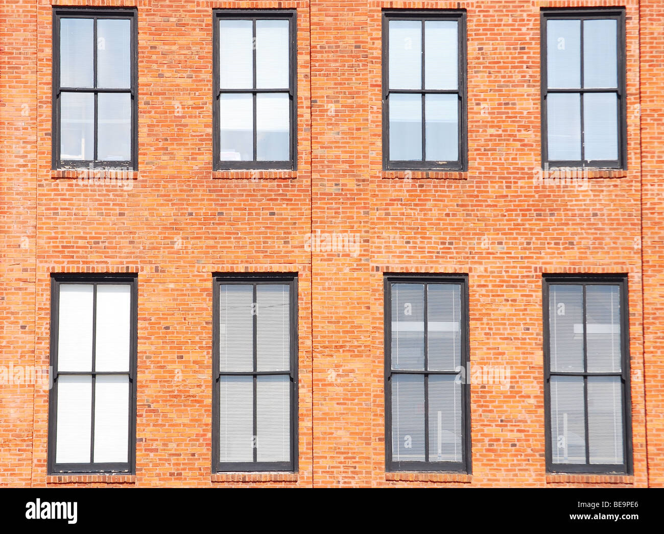 Due file di Windows su un edificio in mattoni Foto Stock