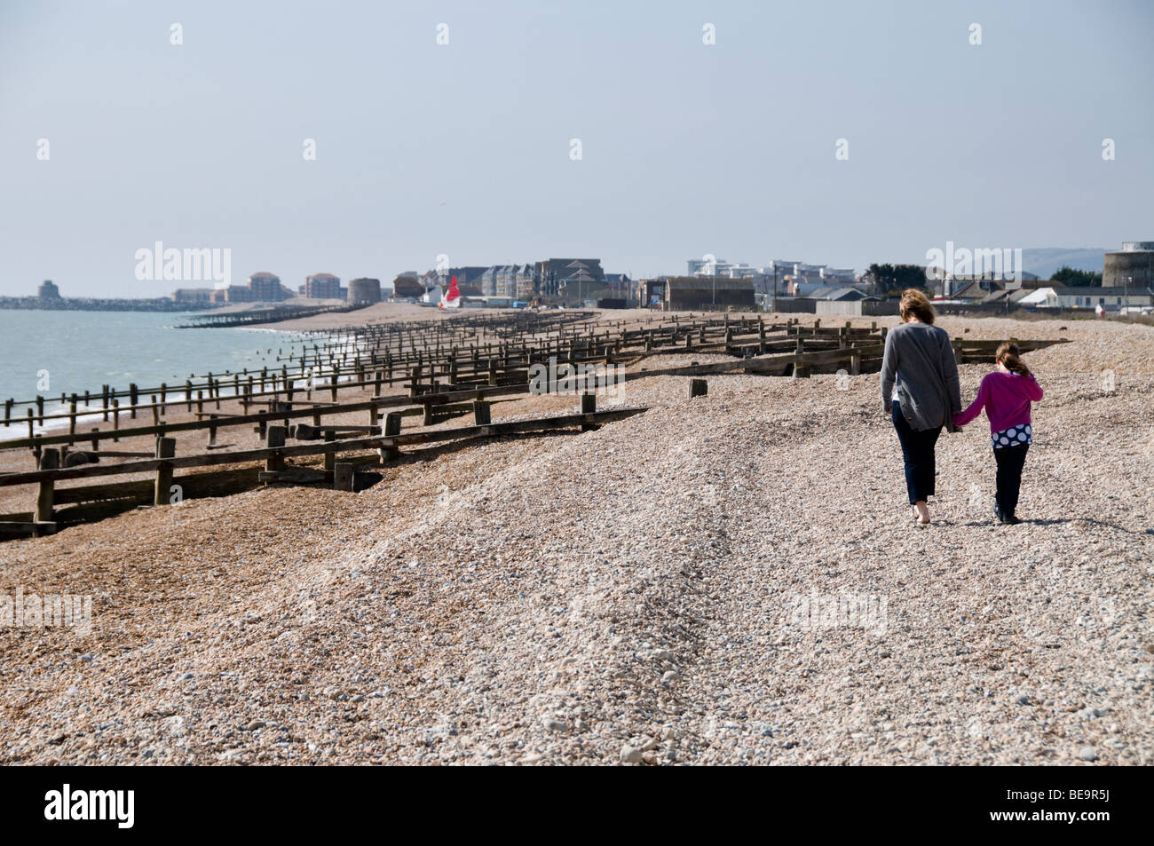 Mamma e figlia di camminare sulla spiaggia, Pevensey Bay, East Sussex, Regno Unito Foto Stock