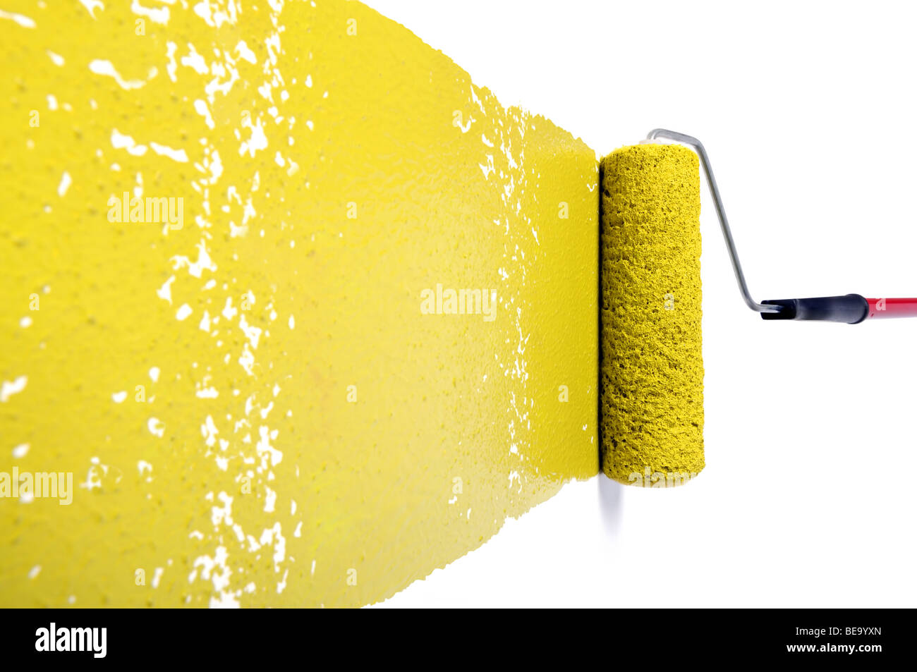 Rullo di dolore con vernice gialla sul muro bianco Foto Stock