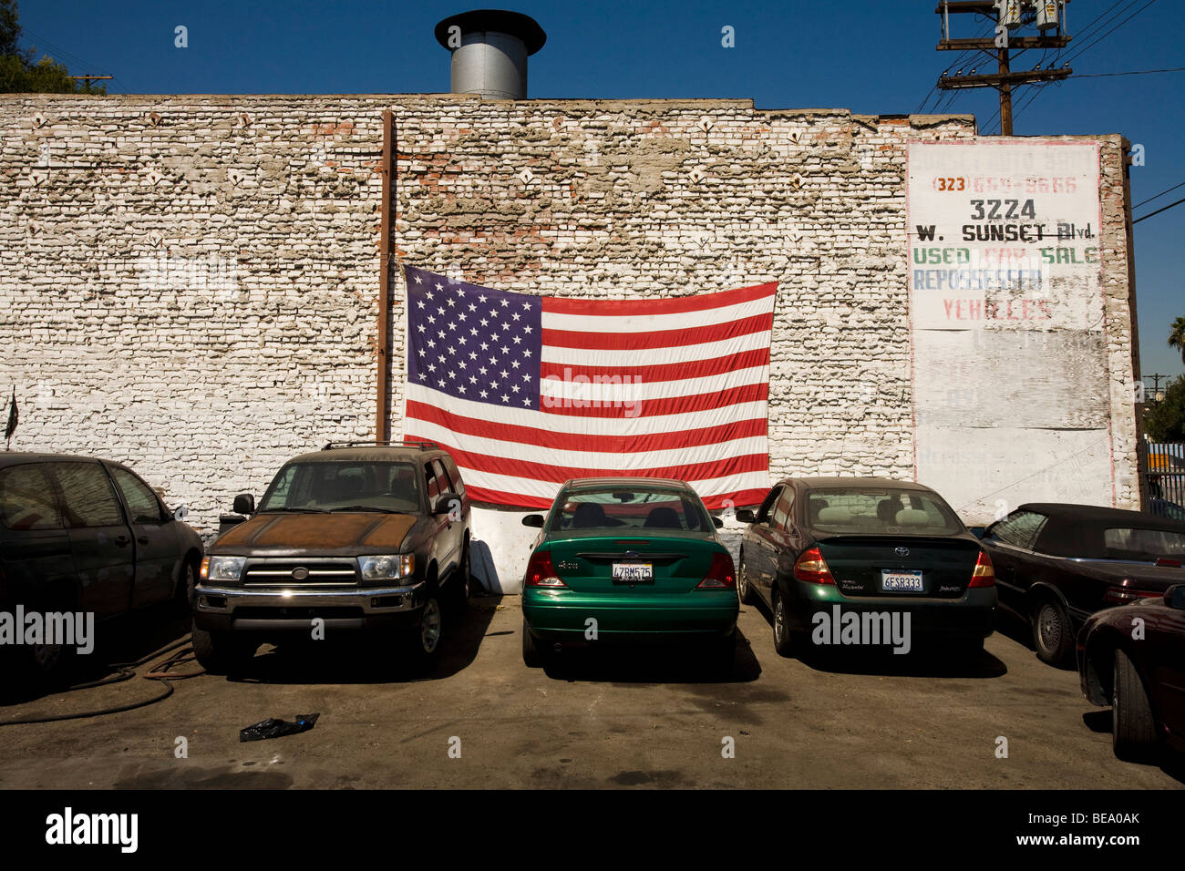 Un usato concessionaria auto su Sunset Boulevard di visualizzazione di una bandiera americana. Los Angeles, California, Stati Uniti d'America Foto Stock