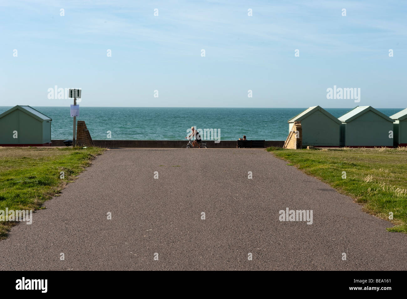 Beach Huts a Brighton con ciclista in vista Foto Stock
