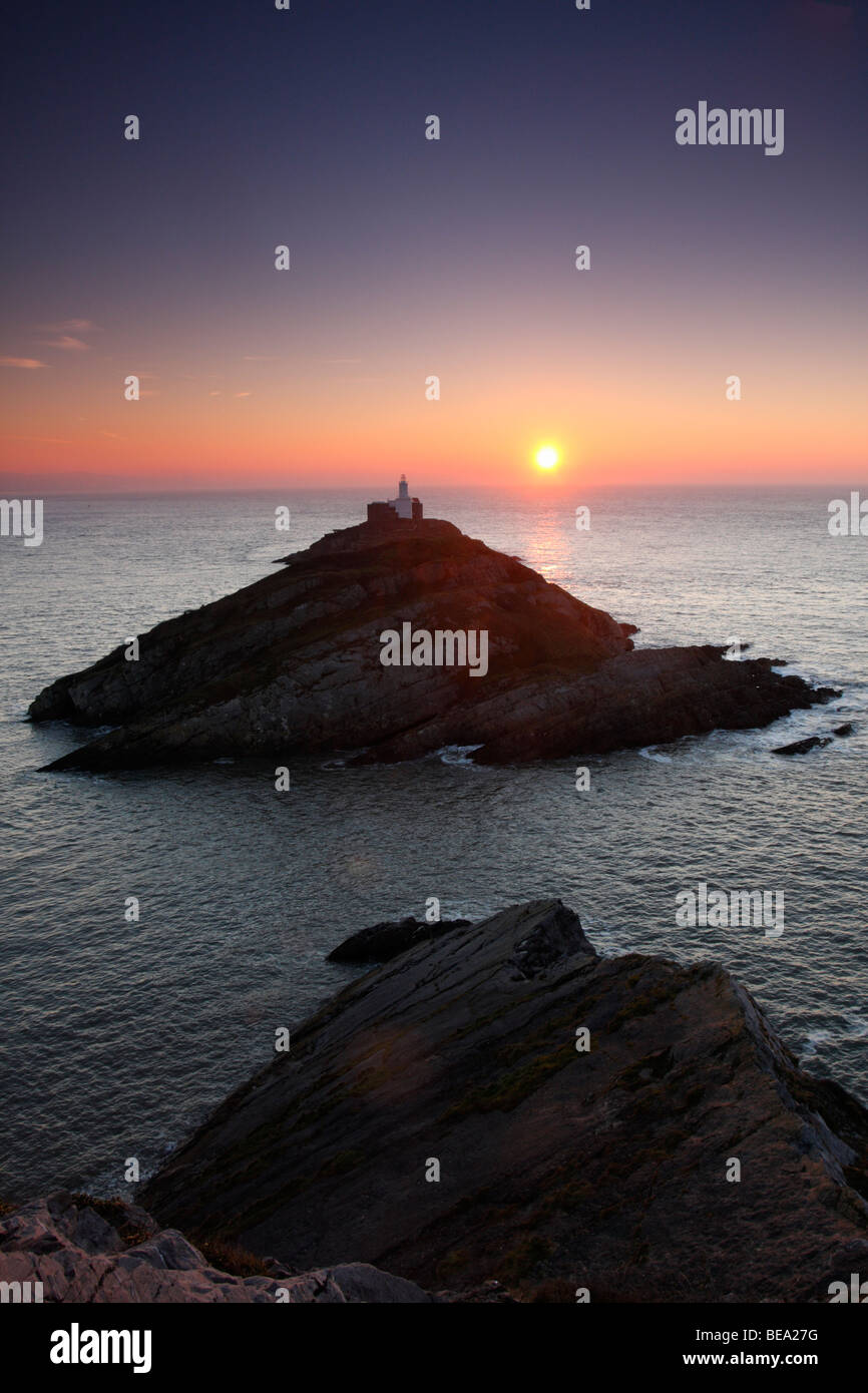 Il sorgere del sole sulla testa di Mumbles, Penisola di Gower vicino a Swansea, West Glamorgan, South Wales, Regno Unito Foto Stock