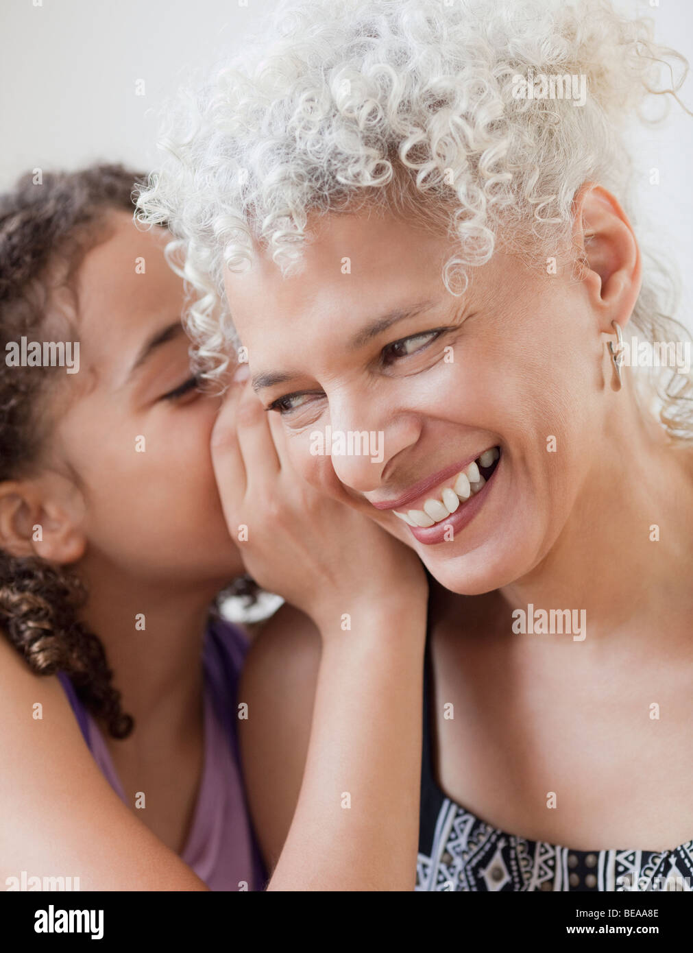 La nipote whispering in nonna orecchio Foto Stock