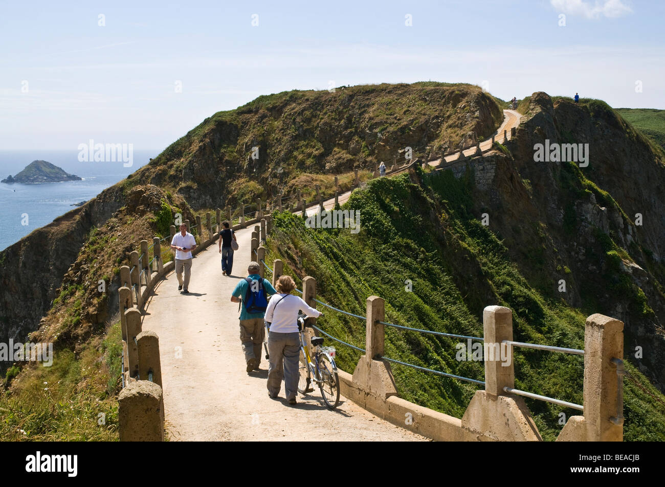 Dh LA COUPEE SARK isola turisti e biciclette su La Coupee causeway road Foto Stock