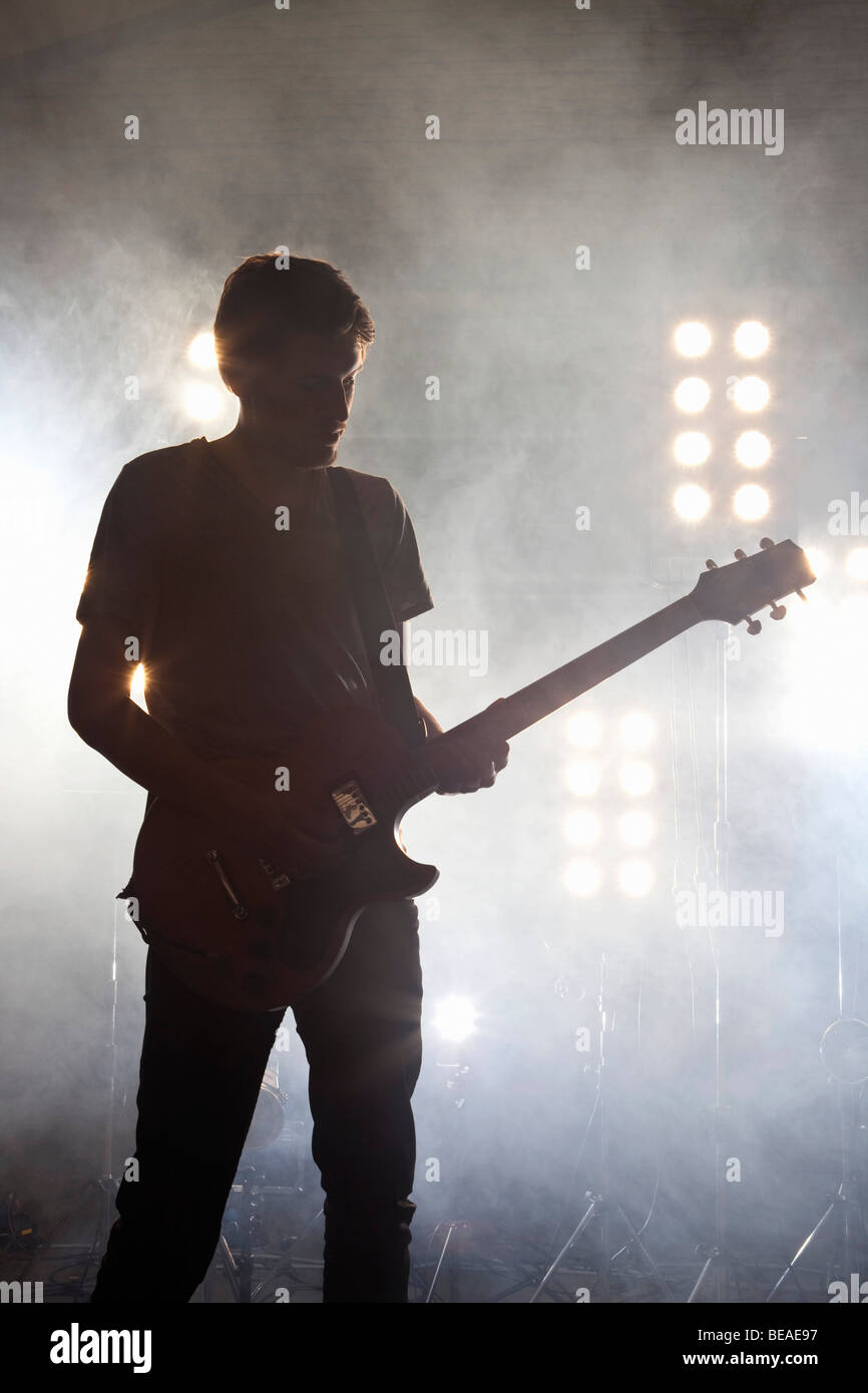 Un musicista rock suonando una chitarra su un palco Foto Stock