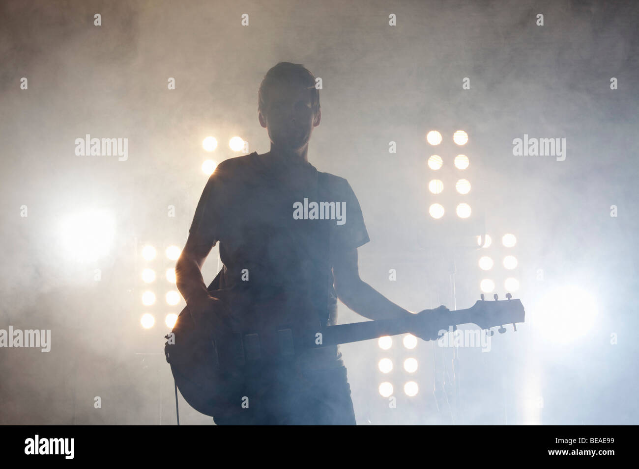 Un musicista rock suonando una chitarra su un palco Foto Stock