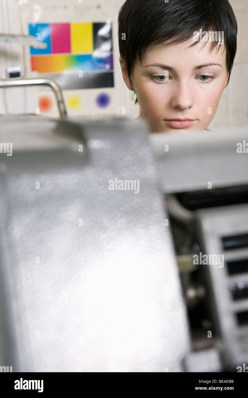 Una donna che lavora in una delle stampanti Foto Stock