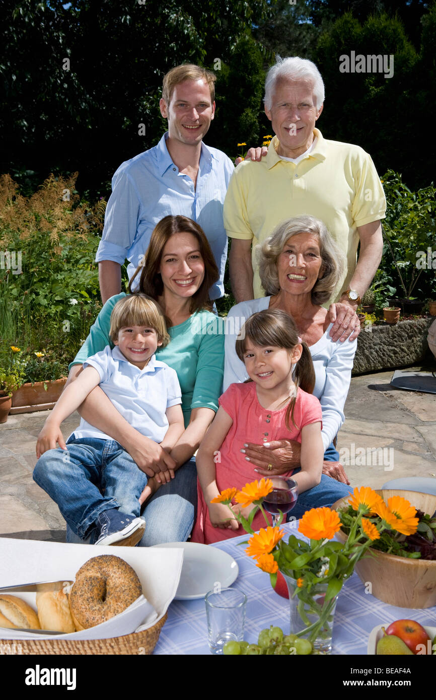 Un multi-generazionale famiglia avente la colazione, all'aperto Foto Stock