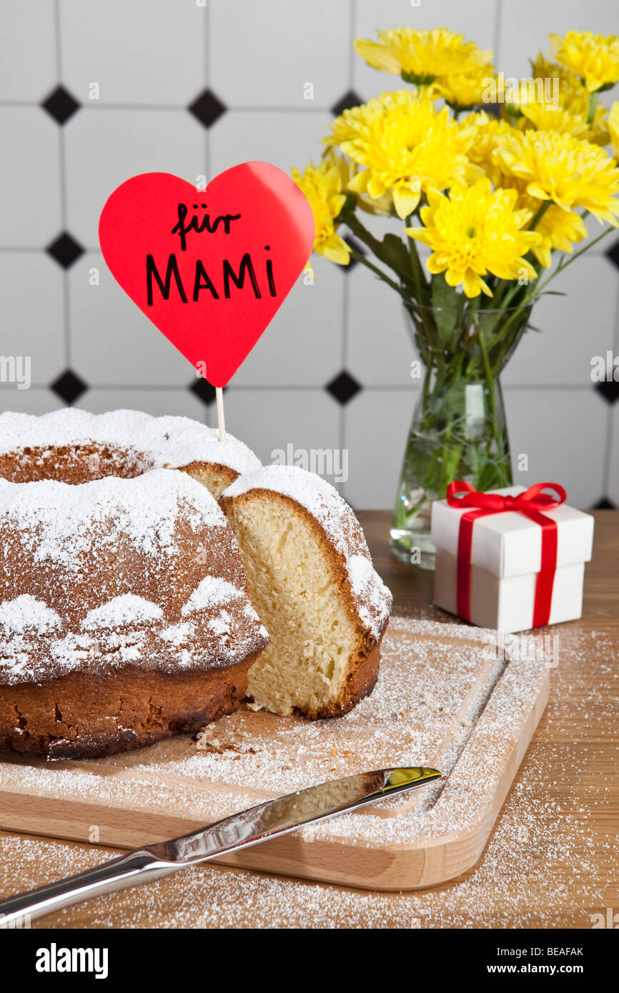 Una torta di Bundt, fiori e un regalo per la Festa della mamma in Germania Foto Stock