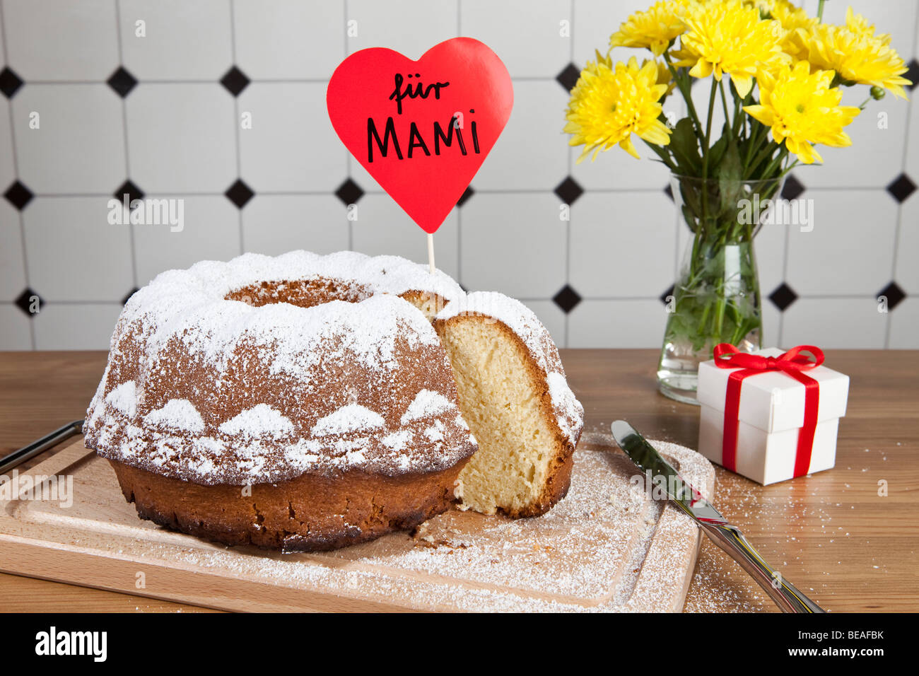 Una torta di Bundt, fiori e un regalo per la Festa della mamma in Germania Foto Stock