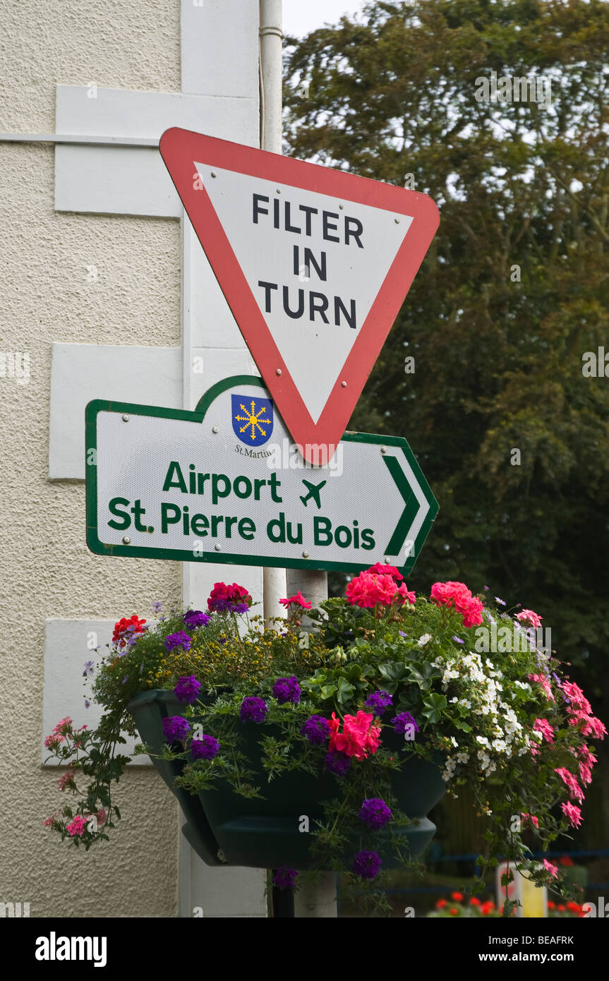 dh ST MARTIN GUERNSEY Guernsey raccordo di traffico filtro in segno di svolta con fiori cartello strada canale isole Foto Stock
