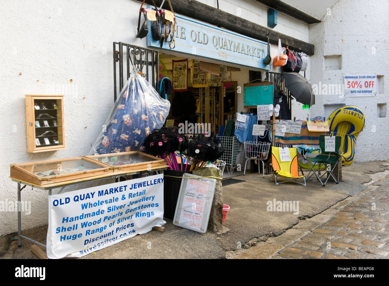 Shop visualizzazione delle merci e dei beni in vendita al di fuori di un ingresso ad un mercato interno in St Ives Cornwall Regno Unito Foto Stock
