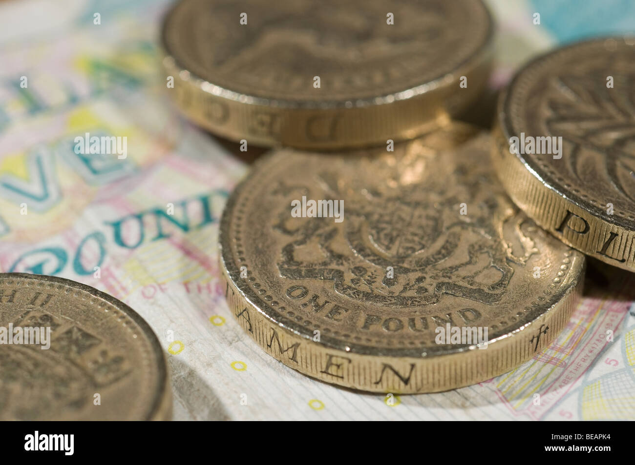 British una libbra di monete in appoggio su un cinque Pound nota Foto Stock