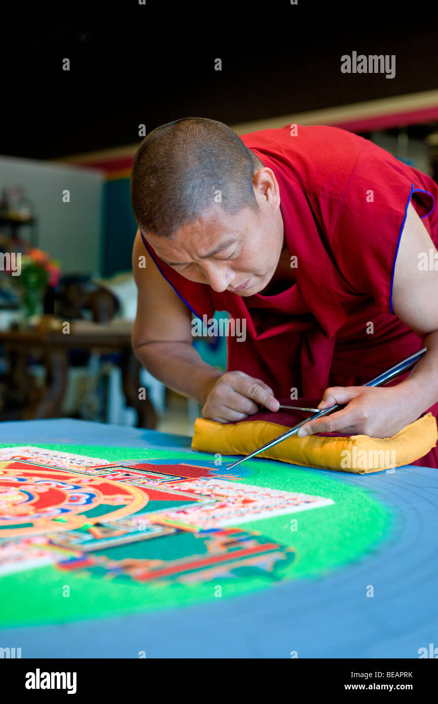 Monaco tibetano Yeshi Choedup opere attentamente su un coloratissimo Mandala di sabbia in Ruidoso, Nuovo Messico. Foto Stock