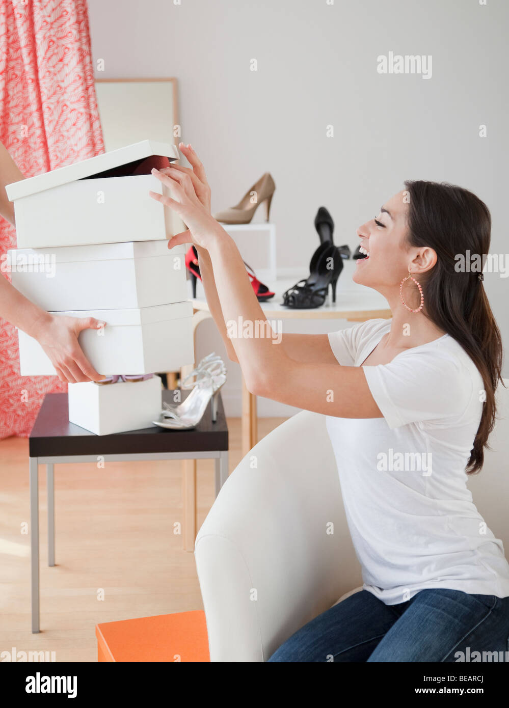 Donna ispanica occhiatura le scatole di scarpe in negozio Foto Stock