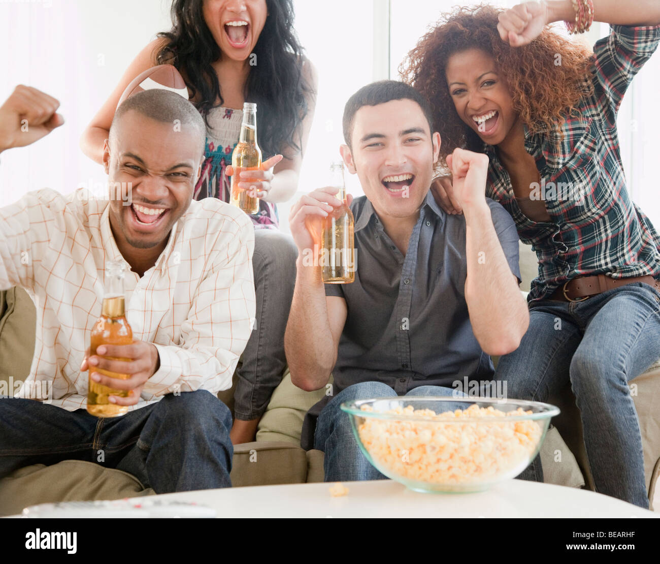 Gli amici a bere birra e guardare il calcio in televisione Foto Stock