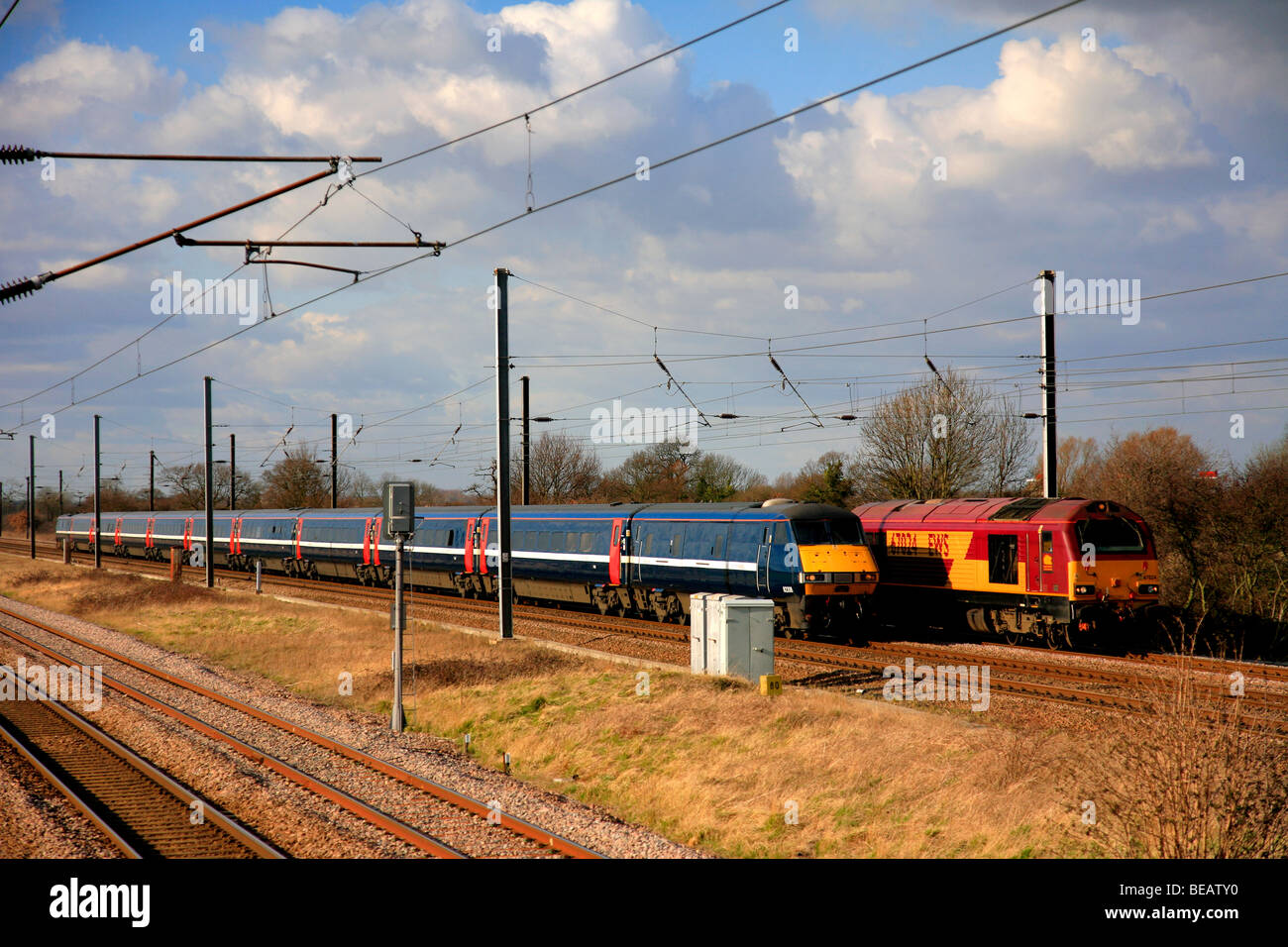 La National Express 82207 DVT treno elettrico passante EWS Diesel 67024 Loco East Coast Main Line Railway Peterborough Cambridgeshire Foto Stock