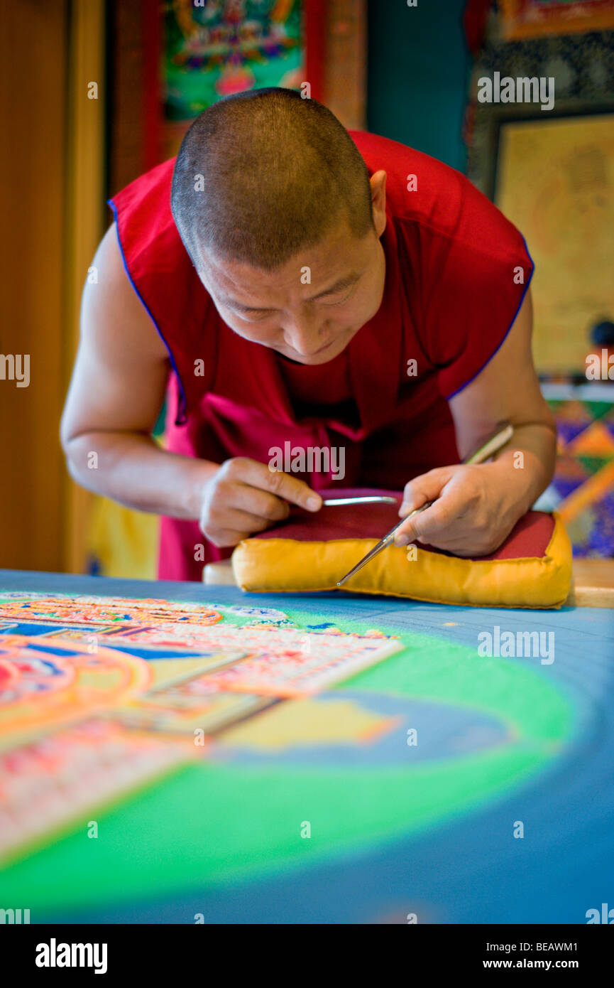 Monaco tibetano Yeshi Choedup opere attentamente su un coloratissimo Mandala di sabbia in Ruidoso, Nuovo Messico. Foto Stock