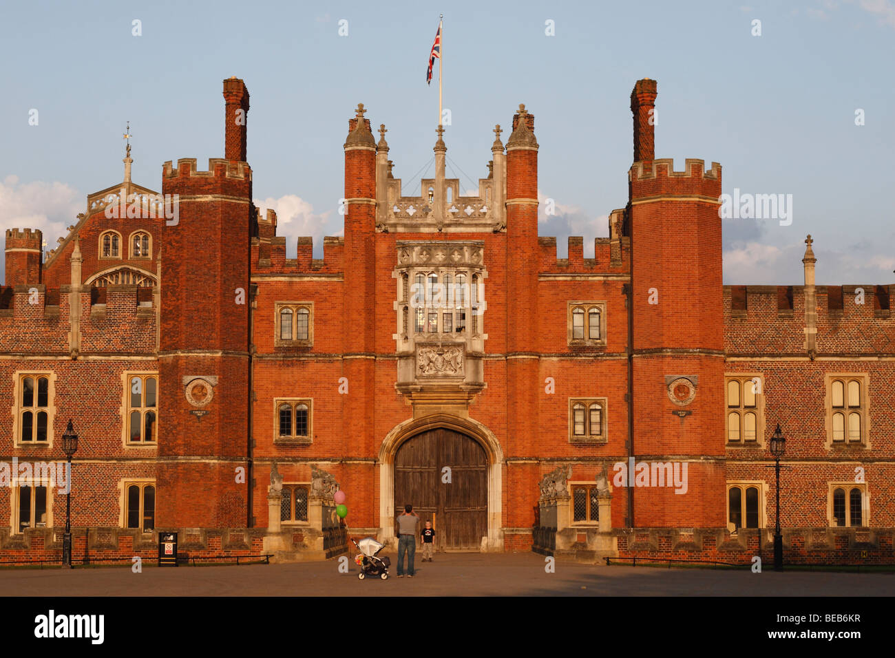 Un padre fotografie di suo figlio di fronte all'ingresso principale dell'Hampton Court Palace, Surrey, Regno Unito su una bella sera d'estate. Foto Stock