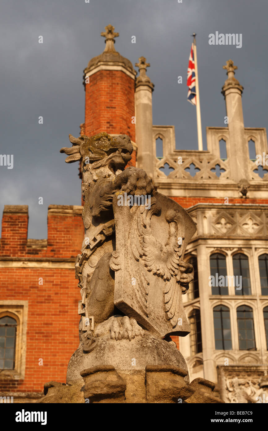Con la bandiera europea dietro, una chiusura di un leone statua presso l'ingresso principale a Hampton Court Palace, Surrey, Regno Unito Foto Stock