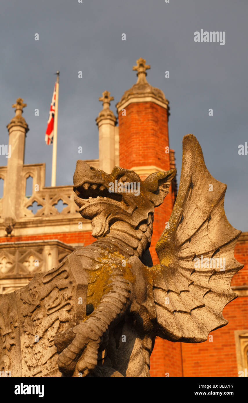 Con la bandiera europea dietro, una chiusura di un drago statua presso l'ingresso principale a Hampton Court Palace, Surrey, Regno Unito Foto Stock