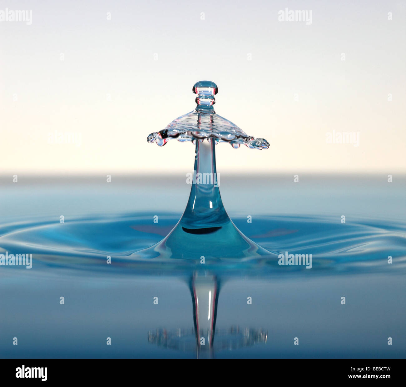 Gocce d'acqua collidere al di sopra di una superficie Foto Stock