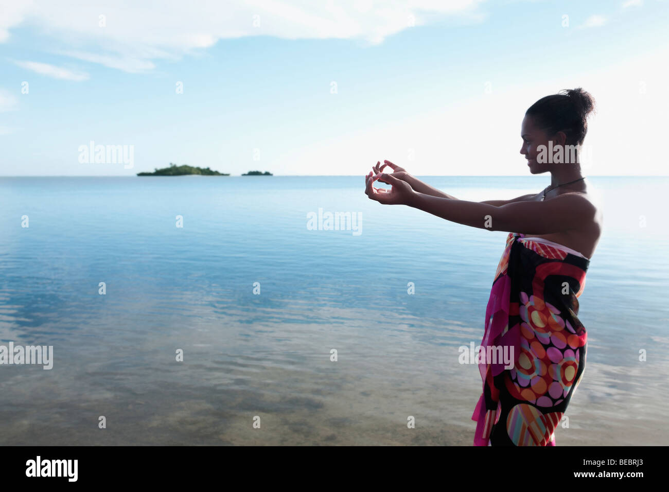Donna stretching le sue braccia verso il mare Foto Stock