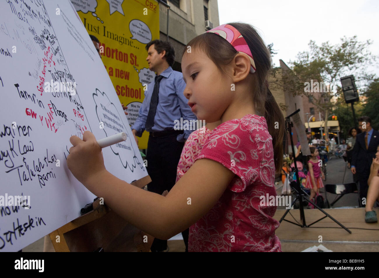 Kids firmare una cartolina gigante chiedendo NYS Gov David A. Paterson per mettere una scuola media in un edificio a 75 Morton Street a New York Foto Stock