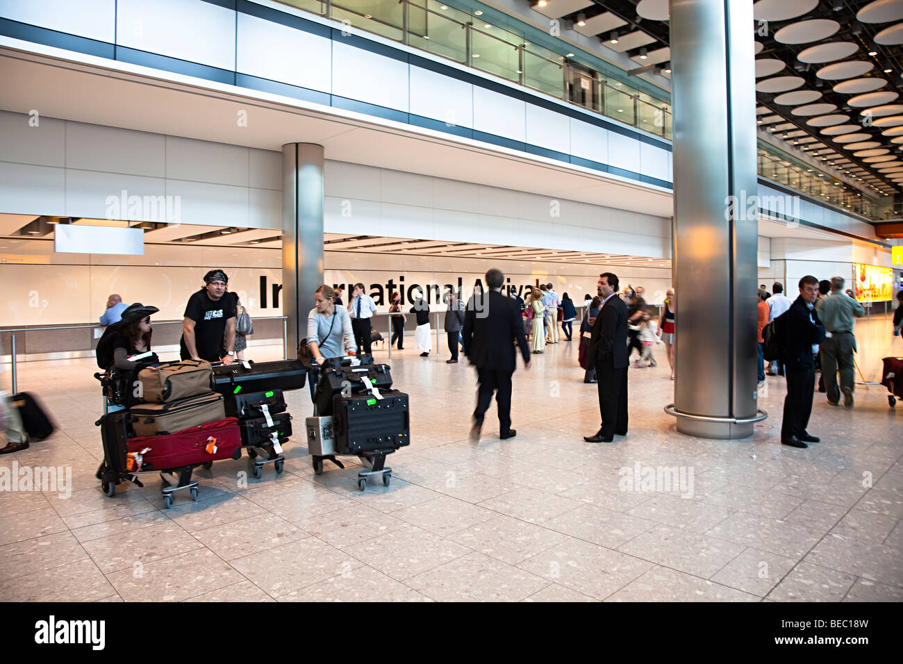 Persone presso gli arrivi internazionali aeroporto di Heathrow Londra Inghilterra REGNO UNITO Foto Stock